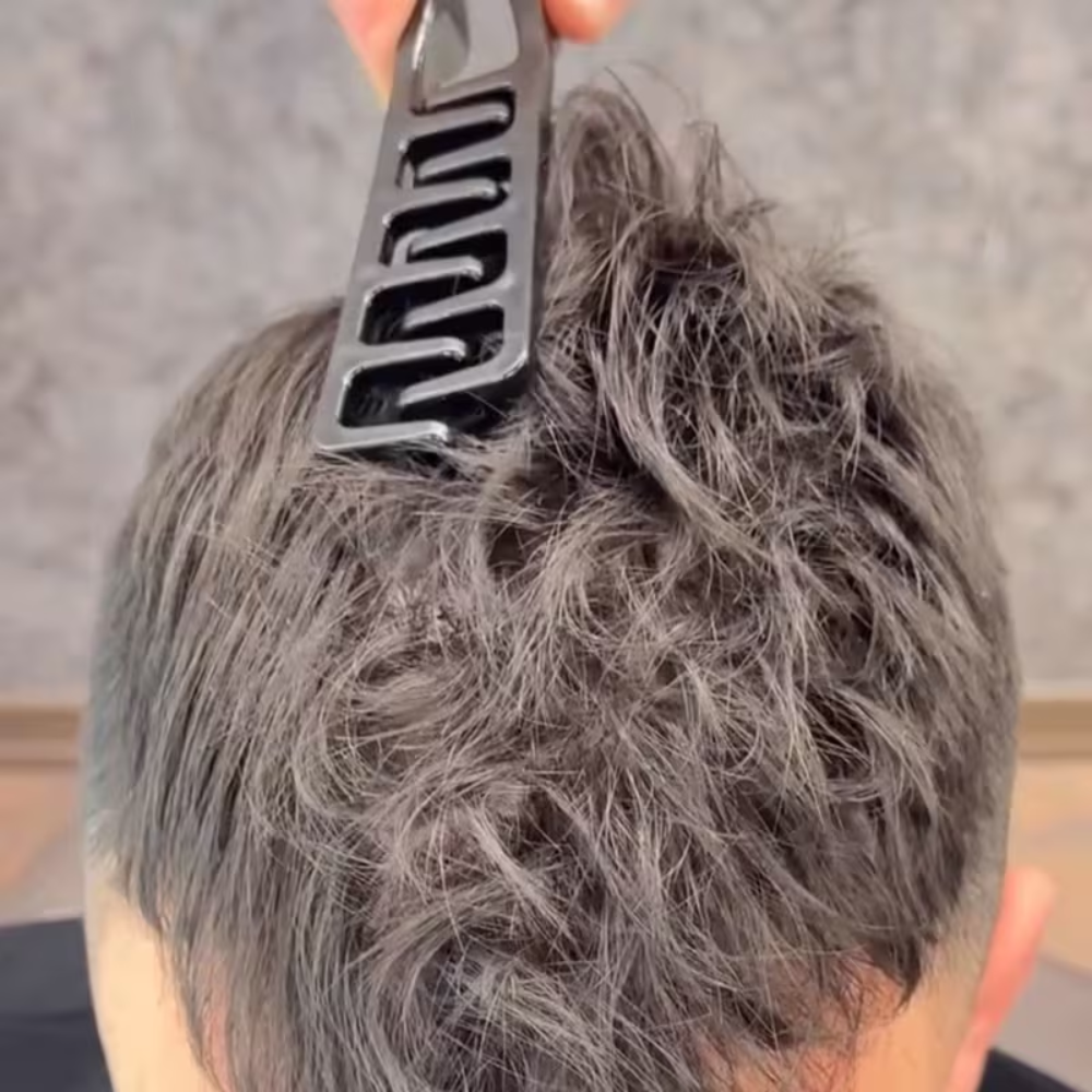 Person with textured gray hair using a Black Red Magic comb